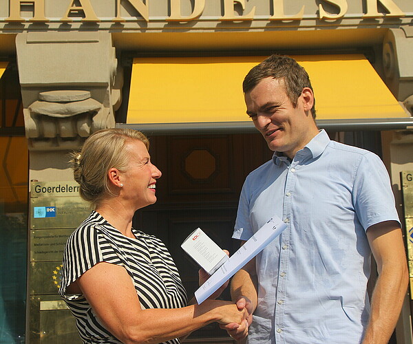 Peggy Wöhlermann gratuliert David Oberbichler vor dem Haus der IHK