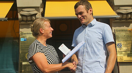 Peggy Wöhlermann gratuliert David Oberbichler vor dem Haus der IHK